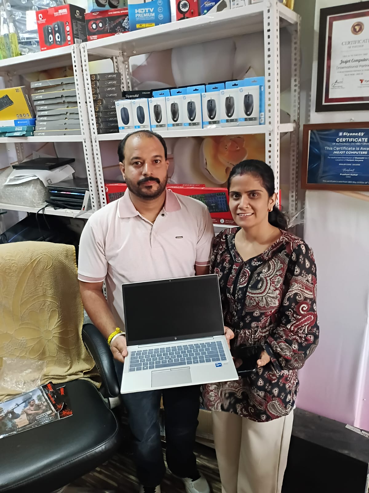 A laptop handover photographed in the store